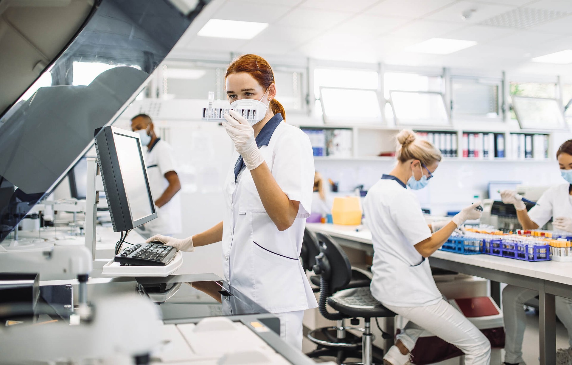 Woman in front of a computer inspecting medical equipment