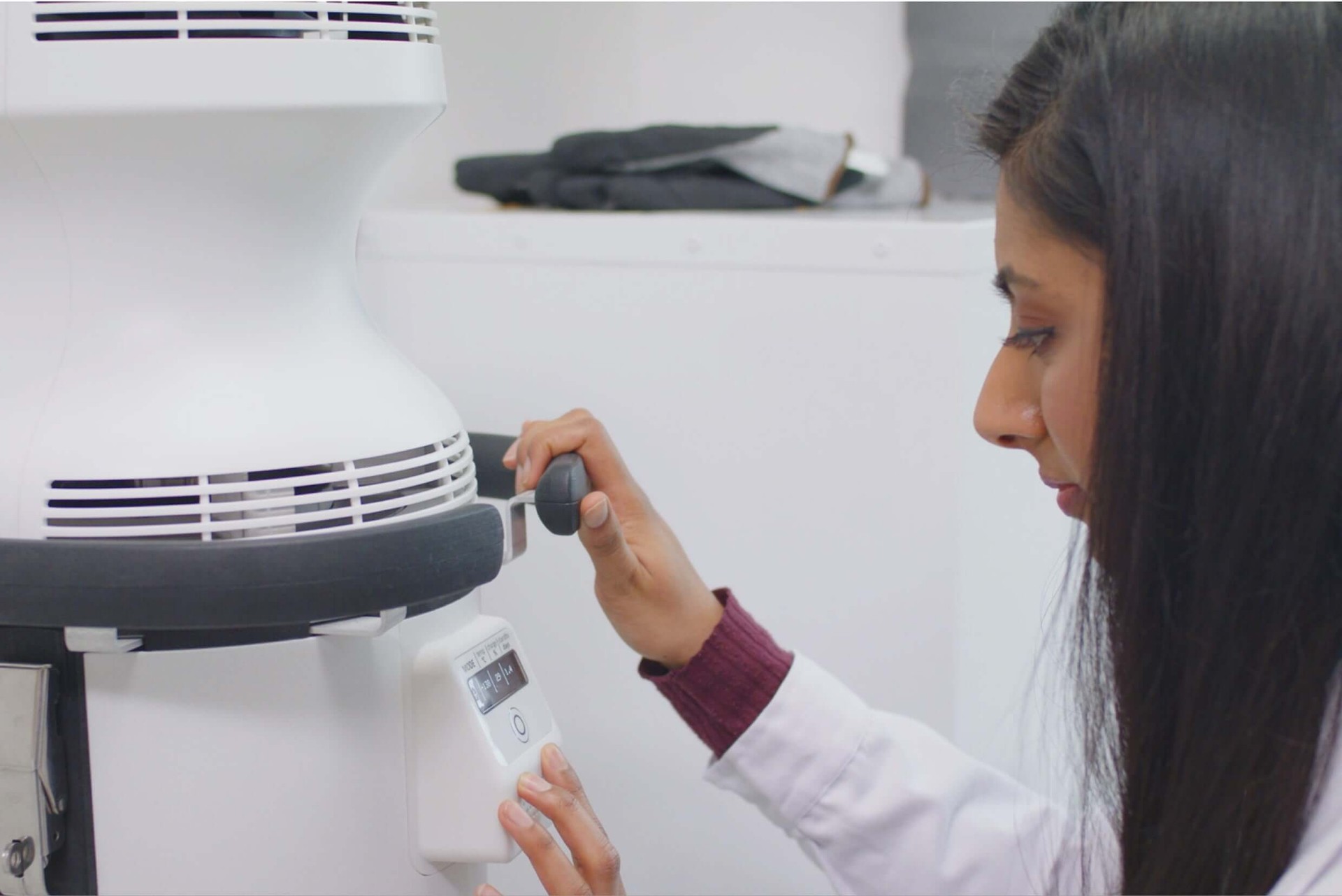 Woman using controls of Cytiva VIA Capsule™ system