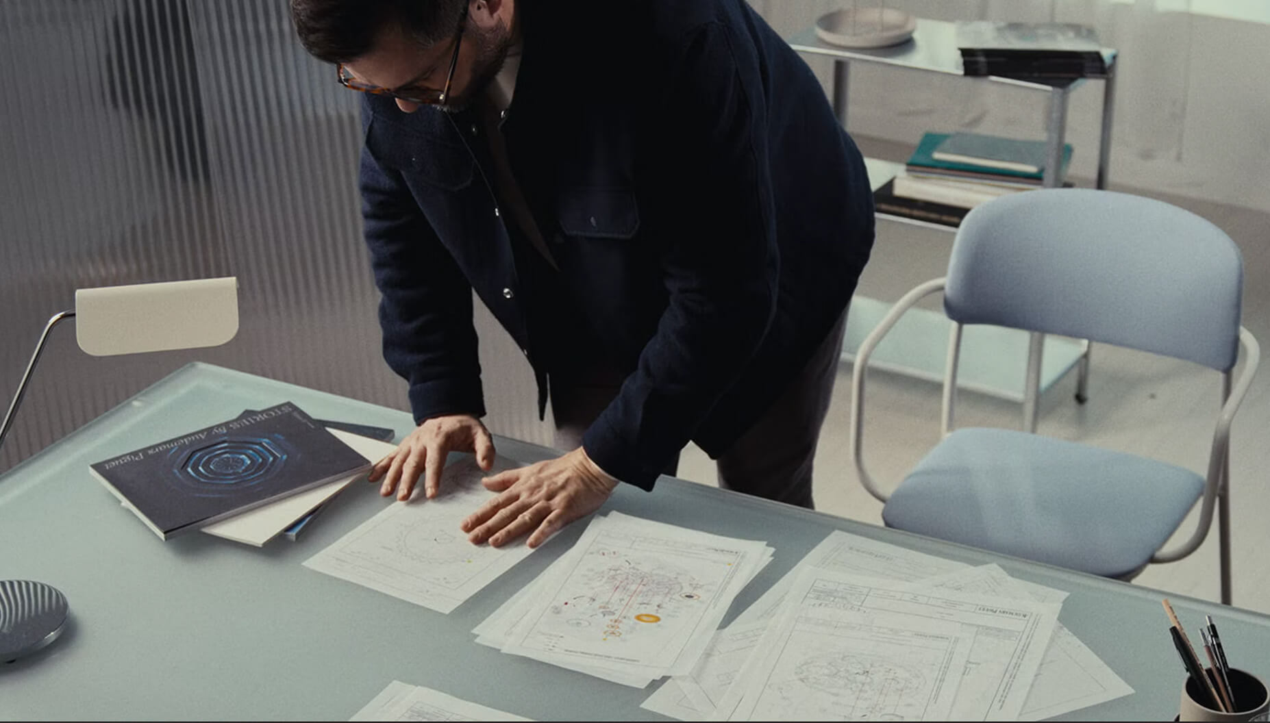 Man in front of drawings on a table